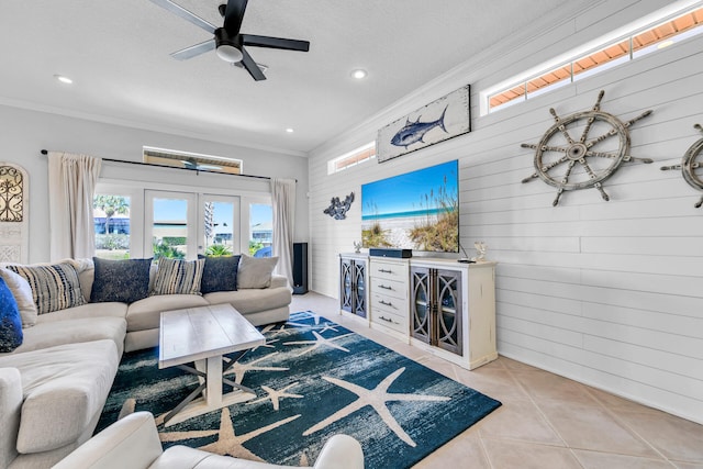 living area with ceiling fan, wooden walls, recessed lighting, ornamental molding, and tile patterned floors