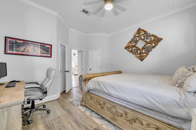 bedroom with crown molding, visible vents, light wood-style flooring, a ceiling fan, and baseboards