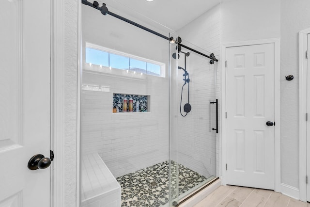 full bath featuring a shower stall and wood finished floors