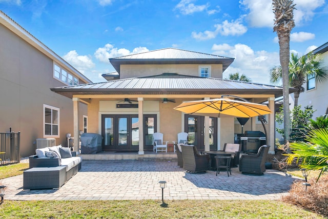 back of property featuring french doors, a patio, stucco siding, a standing seam roof, and metal roof