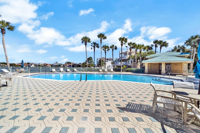 pool with fence and a patio