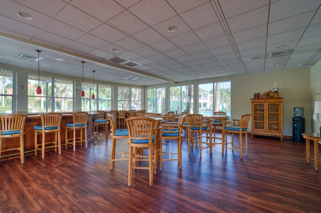 dining area with visible vents, a drop ceiling, and wood finished floors