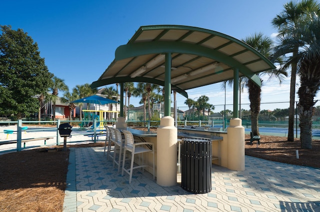 view of community with outdoor dry bar and fence