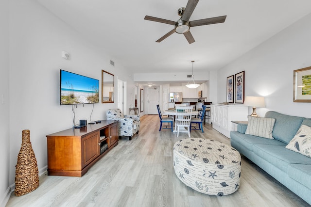 living room with light wood-type flooring and ceiling fan