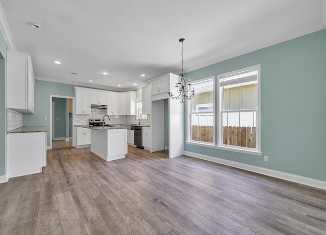 kitchen featuring a center island with sink, light hardwood / wood-style flooring, white cabinets, decorative light fixtures, and black dishwasher