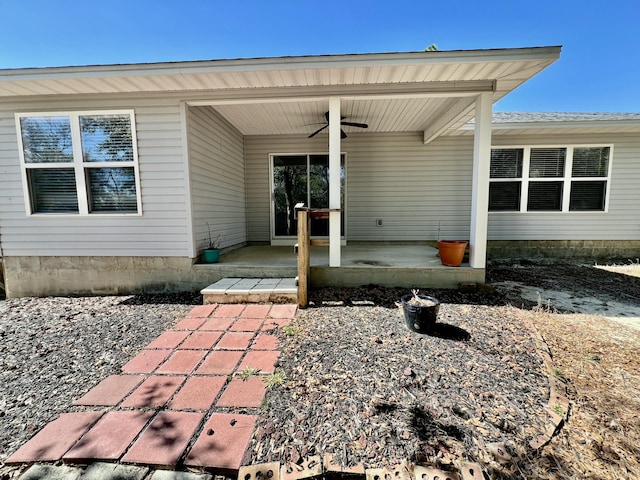 entrance to property with a ceiling fan and a patio area