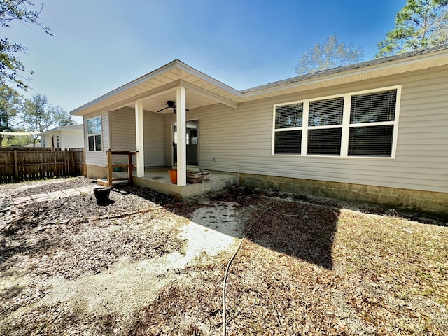 view of front of property featuring ceiling fan, fence, and a patio