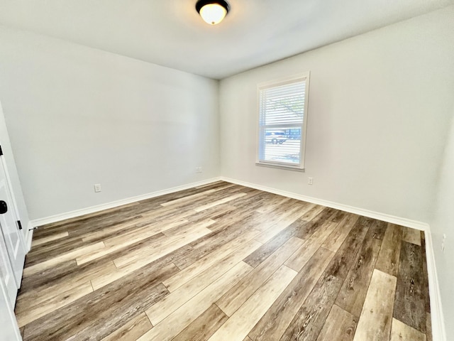 empty room with light wood-type flooring and baseboards