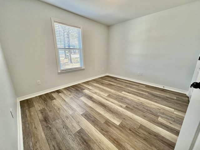 unfurnished room with baseboards and wood finished floors