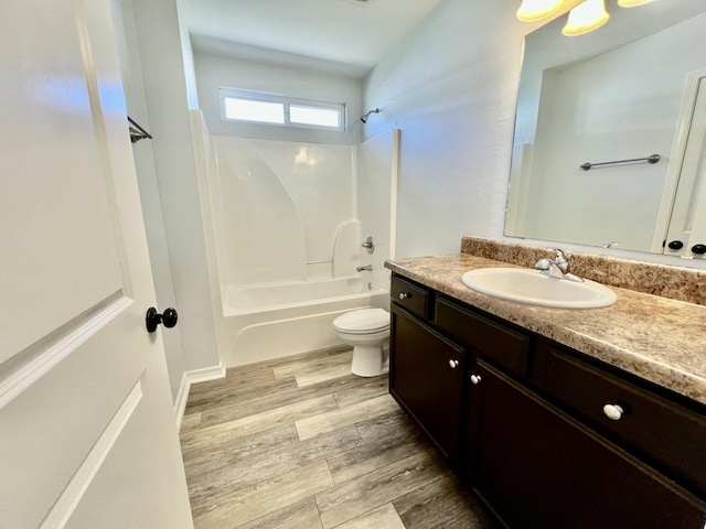 bathroom featuring toilet, bathtub / shower combination, wood finished floors, and vanity