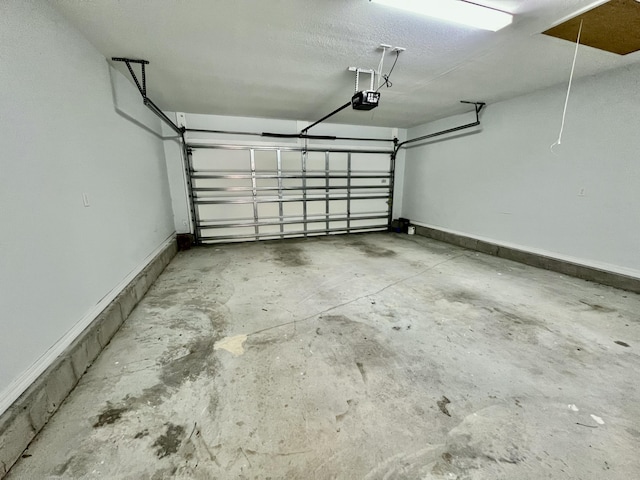 garage with baseboards and a garage door opener