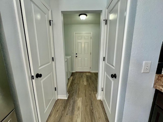 hallway featuring light wood-type flooring and baseboards