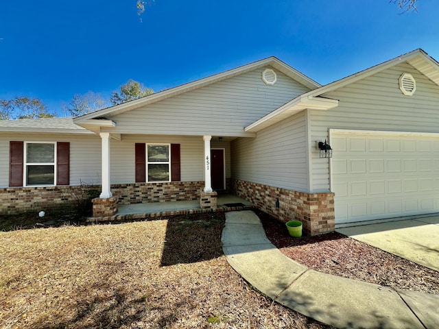 ranch-style house with covered porch, brick siding, and a garage