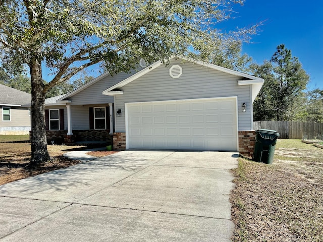 single story home featuring a garage, driveway, brick siding, and fence