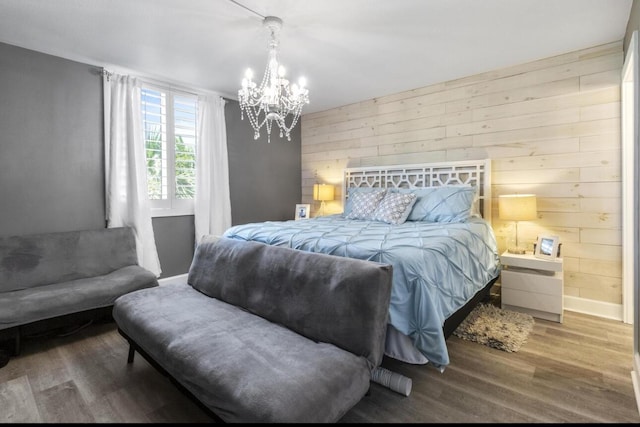 bedroom with hardwood / wood-style floors, a chandelier, and wooden walls