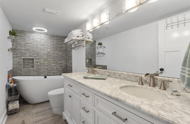 bathroom with a fireplace, vanity, toilet, and a tub to relax in