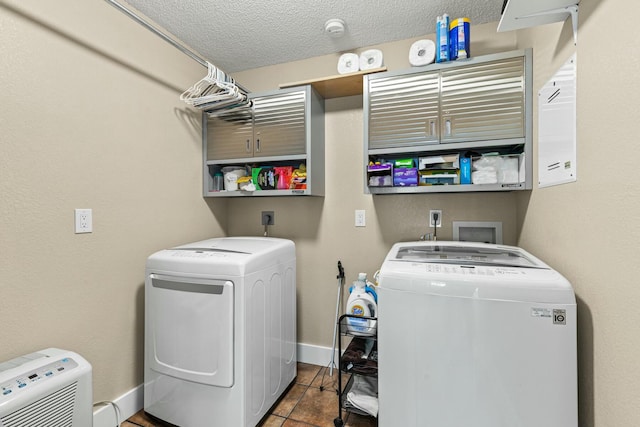 washroom with baseboards, a textured ceiling, and independent washer and dryer