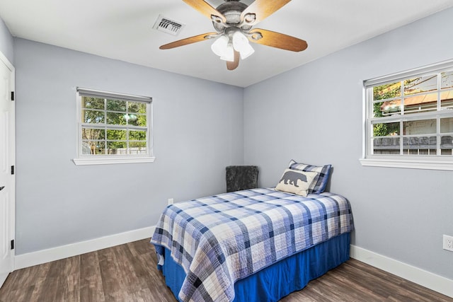 bedroom featuring dark wood-type flooring, visible vents, and multiple windows