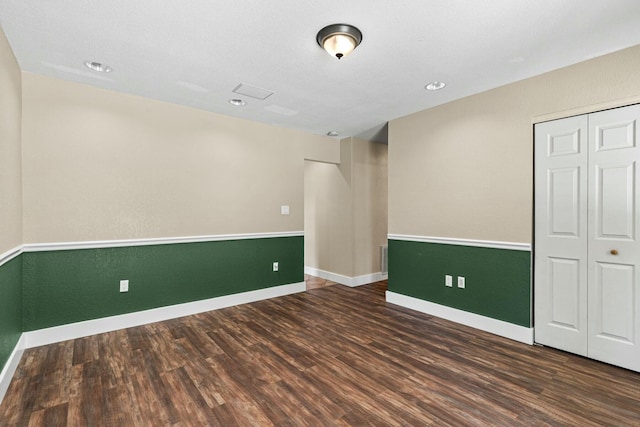 empty room with baseboards and dark wood finished floors