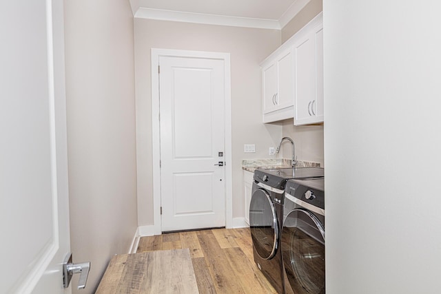 laundry room with ornamental molding, cabinets, independent washer and dryer, and light wood-type flooring