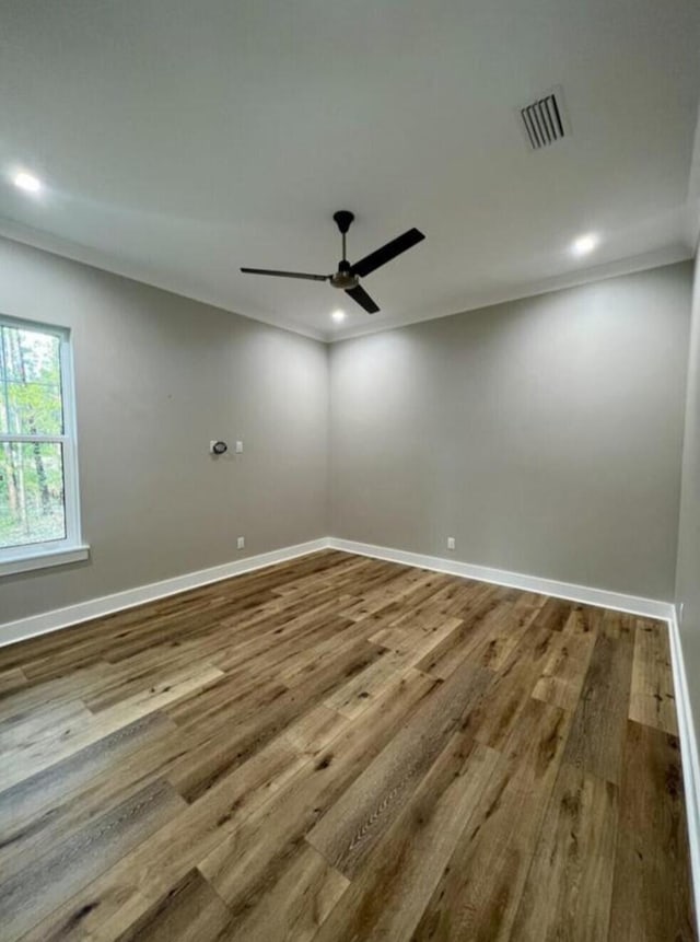 spare room with hardwood / wood-style floors, crown molding, and ceiling fan