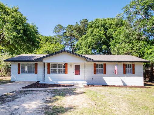 single story home featuring covered porch and a front lawn