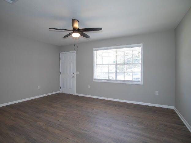 unfurnished room featuring dark hardwood / wood-style floors and ceiling fan