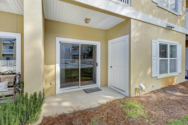 view of exterior entry featuring a patio area