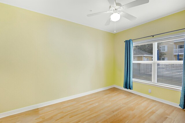 empty room with ceiling fan, hardwood / wood-style flooring, and a wealth of natural light
