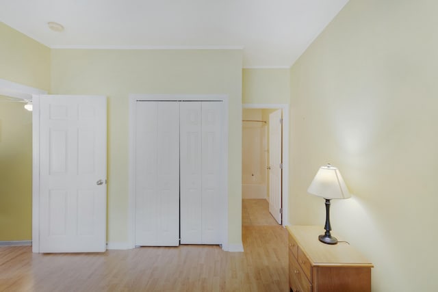 unfurnished bedroom with light hardwood / wood-style flooring, a closet, and ornamental molding