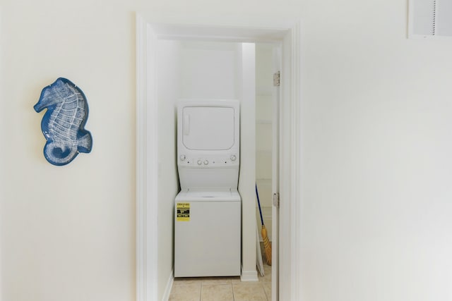 washroom featuring light tile patterned flooring and stacked washer / dryer