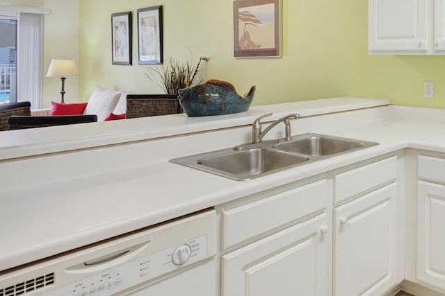kitchen featuring white cabinets, sink, and white dishwasher
