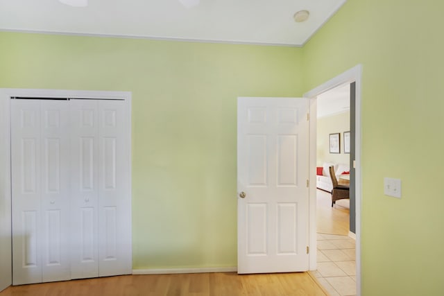 unfurnished bedroom featuring ornamental molding, a closet, and light hardwood / wood-style floors