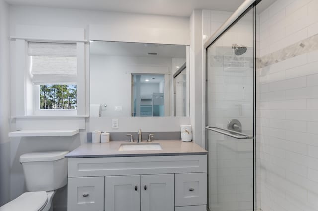 full bath with a stall shower, visible vents, vanity, and toilet