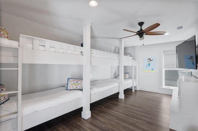 bedroom featuring a ceiling fan, visible vents, and wood finished floors