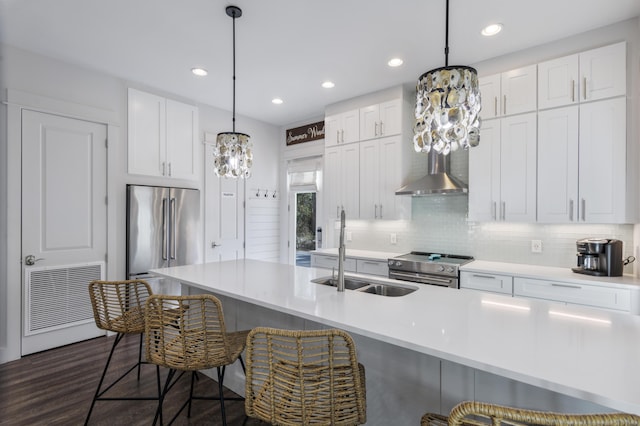 kitchen featuring appliances with stainless steel finishes, a sink, backsplash, and a kitchen bar