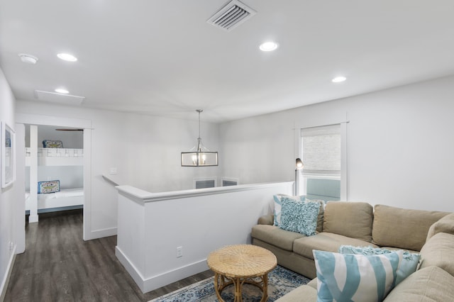 living room featuring a notable chandelier, recessed lighting, dark wood-type flooring, visible vents, and baseboards