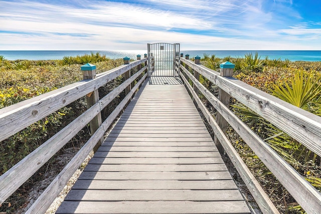 view of dock featuring a water view and a beach view