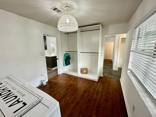 interior space featuring dark hardwood / wood-style flooring, washer / clothes dryer, and a textured ceiling