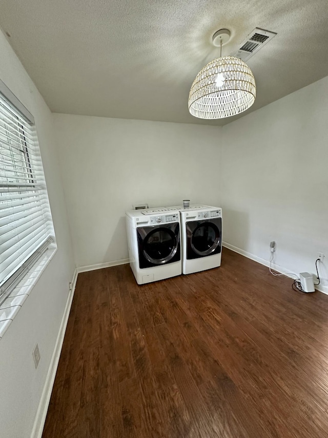 laundry area with washing machine and dryer, a textured ceiling, and dark hardwood / wood-style floors