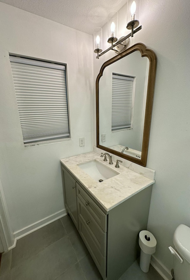 bathroom featuring toilet, a textured ceiling, tile patterned flooring, and vanity