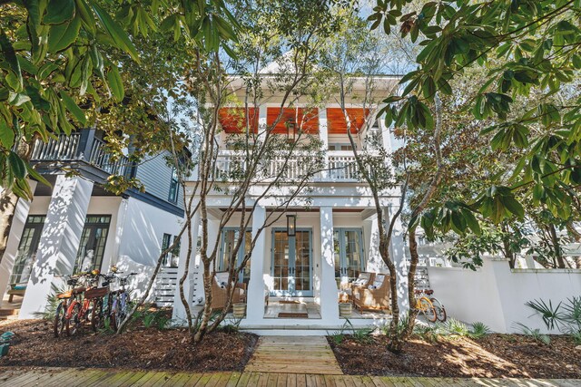 view of front facade featuring a balcony, french doors, and stucco siding