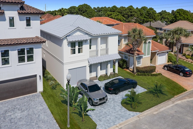 mediterranean / spanish-style home featuring a tiled roof, decorative driveway, and stucco siding