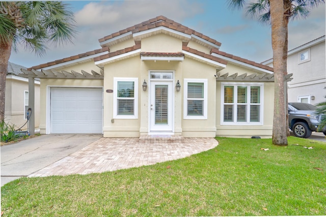 mediterranean / spanish-style house with a garage, a front yard, concrete driveway, and stucco siding