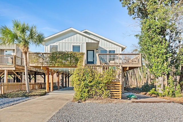 raised beach house featuring a carport, driveway, and board and batten siding