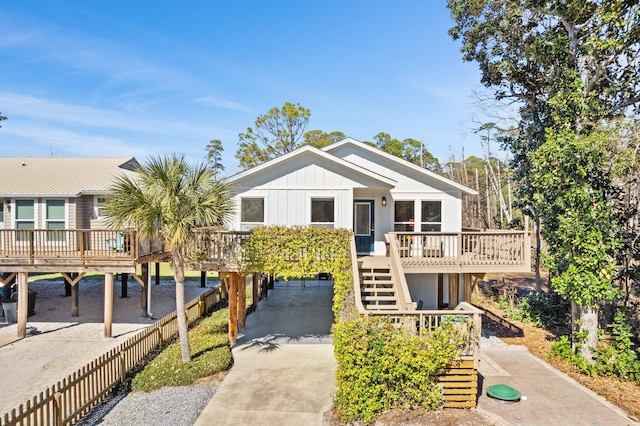 view of front of home featuring fence private yard, a deck, driveway, stairway, and a carport