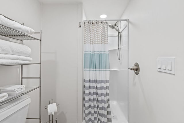 bathroom featuring toilet and a shower with shower curtain