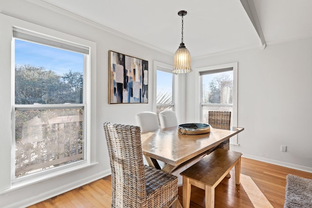 dining area featuring baseboards, ornamental molding, and wood finished floors