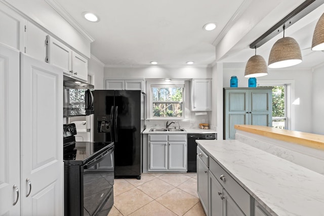 kitchen featuring light tile patterned floors, crown molding, black appliances, pendant lighting, and a sink