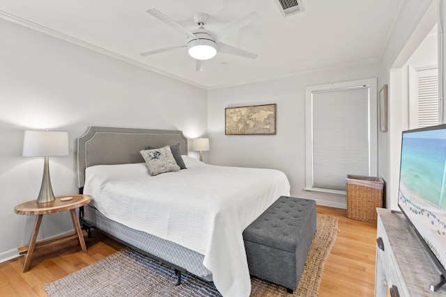 bedroom featuring crown molding, visible vents, a ceiling fan, light wood-type flooring, and baseboards